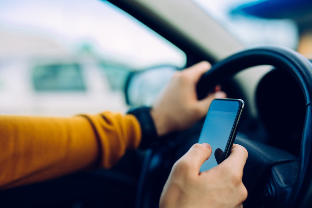 a-driver-using-their-cellphone-while-behind-the-wheel